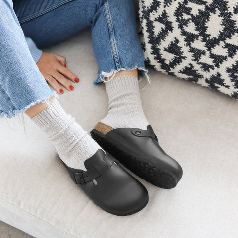 Woman wearing black leather clog